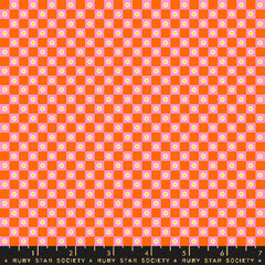 Checkered pattern with orange and pink squares with small flowers with ruler
