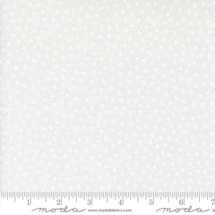 Patterned fabric with small white shapes on a light background with ruler