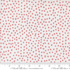 Patterned fabric with small red shapes on a white background with ruler