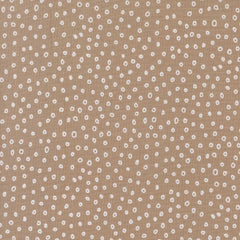 Patterned fabric with small white shapes on a beige background