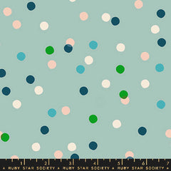 Pattern of colorful dots on a light blue background with ruler