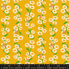 Pattern of white daisies with orange centers and snails on a gold background with ruler