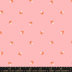Pattern of small mushrooms on a pink background with ruler