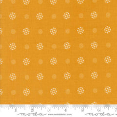 Patterned fabric with white geometric shapes on a yellow background with ruler