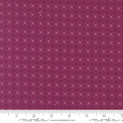 Patterned fabric with a geometric design on a magenta background with ruler