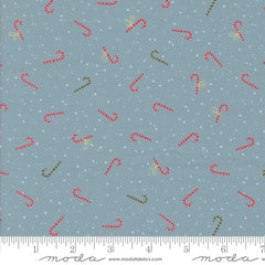 Pattern of red and green candy canes on a blue fabric background with white dots with ruler