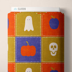 Checkered pattern of Halloween themed items with blue, orange, and gold colors on a fabric roll