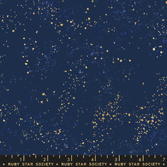 Pattern of multi-colored speckles on a navy background with ruler