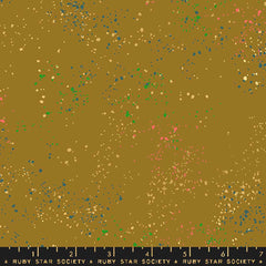 Pattern of multi-colored speckles on a light brown background with ruler