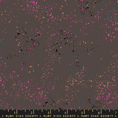 Pattern of multi-colored speckles on a dark gray background with ruler