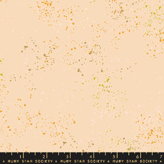 Pattern of multi-colored speckles on a light pink background with ruler