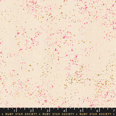 Pattern of multi-colored speckles on a light pink background with ruler