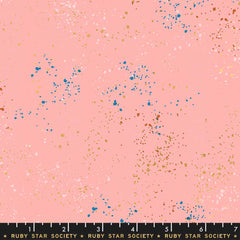 Pattern of multi-colored speckles on a pink background with ruler