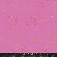 Pattern of multi-colored speckles on a light purple background with ruler