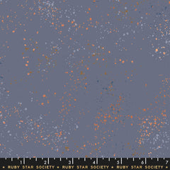Pattern of multi-colored speckles on a dark blue background with ruler