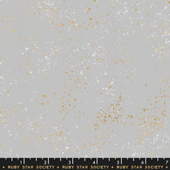 Pattern of multi-colored speckles on a light gray background with ruler