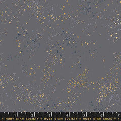 Pattern of multi-colored speckles on a dark gray background with ruler