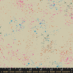 Pattern of multi-colored speckles on a light gray background with ruler