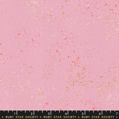 Pattern of multi-colored speckles on a pink background with ruler