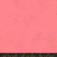 Pattern of multi-colored speckles on a pink background with ruler